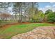 Serene backyard features a stone patio, grassy area, and meticulously maintained landscaping surrounded by mature trees at 3022 Woodbridge Ln, Canton, GA 30114
