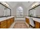 Bright primary bathroom with double vanity, soaking tub, and an arched window for natural lighting at 3022 Woodbridge Ln, Canton, GA 30114