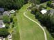 Aerial view of a golf course with a golf cart path, a green, and manicured landscaping at 3022 Woodbridge Ln, Canton, GA 30114