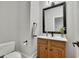 Half bath has a wooden vanity, decorative mirror, and neutral walls at 3022 Woodbridge Ln, Canton, GA 30114