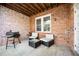 Covered patio area featuring a grill, exposed brick, and comfortable seating at 5888 Riverstone Cir # 15, Atlanta, GA 30339