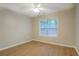Sunlit bedroom features wood-look flooring, a ceiling fan, and a large window at 1917 Kevin Dr, Conyers, GA 30013