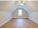 Unique attic bedroom featuring wood-look flooring, a window, and a ceiling fan at 1917 Kevin Dr, Conyers, GA 30013