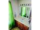 Bathroom with vanity, mirror, and bright green curtains for an airy aesthetic at 204 Millpond Pkwy, Villa Rica, GA 30180