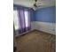 Bedroom with blue painted walls, fan, window with purple drapes, and carpet flooring at 204 Millpond Pkwy, Villa Rica, GA 30180