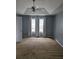 Large bedroom featuring a tray ceiling, neutral walls, and a ceiling fan for added comfort at 204 Millpond Pkwy, Villa Rica, GA 30180