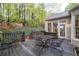 View of the deck with outdoor seating and wooded backyard with manicured landscaping at 205 Wellesley Ct, Woodstock, GA 30189