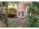 The back exterior of the home features a stone walkway, garden, seating and many plants at 205 Wellesley Ct, Woodstock, GA 30189