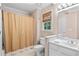 Well-lit bathroom with a shower, vanity, and window at 205 Wellesley Ct, Woodstock, GA 30189
