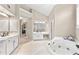 Bright bathroom featuring dual vanities, a soaking tub, and large mirrors at 205 Wellesley Ct, Woodstock, GA 30189