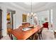 Formal dining room with classic chandelier, seating for eight, and entry into the living room at 205 Wellesley Ct, Woodstock, GA 30189