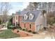 Beautiful two-story brick home with attached two car garage, dormers, and mature landscaping at 205 Wellesley Ct, Woodstock, GA 30189