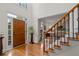 Stunning foyer with soaring ceilings, hardwood floors, staircase, and view into the living room at 205 Wellesley Ct, Woodstock, GA 30189