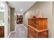 Hallway leading to a bathroom and library, featuring wood floors and a wooden dresser with decorative baskets at 205 Wellesley Ct, Woodstock, GA 30189