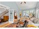 Bright sunroom with large windows, French doors, hardwood floors and staircase at 205 Wellesley Ct, Woodstock, GA 30189