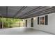 Back patio area featuring corrugated metal awning, concrete slab, and fenced in back yard at 2125 Perkerson Mill Rd, Austell, GA 30106