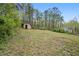 View of the expansive backyard of the home with mature trees and storage sheds at 2125 Perkerson Mill Rd, Austell, GA 30106