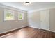 Bright bedroom featuring hardwood floors, neutral walls, trim accents, and two bright windows at 2125 Perkerson Mill Rd, Austell, GA 30106