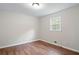Neutral bedroom featuring hardwood floors, one bright window, baseboard heat, and neutral walls at 2125 Perkerson Mill Rd, Austell, GA 30106