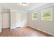 Cozy bedroom featuring hardwood floors, neutral walls, trim accents, and two bright windows at 2125 Perkerson Mill Rd, Austell, GA 30106