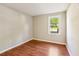 Bedroom with wood floors, neutral walls, white trim, and a bright window overlooking the yard at 2488 Glendale Se Cir, Smyrna, GA 30080