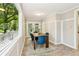 Bright dining area featuring wood-look flooring, stylish blue chairs, and a view of the wooded backyard at 2488 Glendale Se Cir, Smyrna, GA 30080