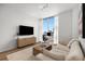 Bright living room features a modern entertainment center, large windows with city views, and a comfortable couch at 855 Peachtree Ne St # 2706, Atlanta, GA 30308