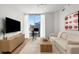 Bright living room features a modern entertainment center, large windows with city views, and a comfortable couch at 855 Peachtree Ne St # 2706, Atlanta, GA 30308