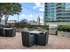 Outdoor seating area with tables, chairs, and a grill with lush landscaping at 855 Peachtree Ne St # 2706, Atlanta, GA 30308