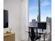 Modern work area with a desk, rolling chair, and large windows overlooking the city skyline and bright, natural light at 855 Peachtree Ne St # 2706, Atlanta, GA 30308