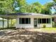 Charming home with green shutters, a covered carport, and a cozy front porch and manicured lawn at 955 Margaret Nw Pl, Atlanta, GA 30318