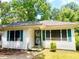 Charming single-story home with white siding and green shutters, set among mature trees at 955 Margaret Nw Pl, Atlanta, GA 30318