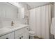 Bright bathroom with a modern vanity, built in shelves, and shower tub combo with a white shower curtain at 155 Glenside Ln, Duluth, GA 30097