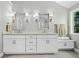 Bathroom featuring double sinks with modern fixtures, white cabinetry, and a large window at 155 Glenside Ln, Duluth, GA 30097