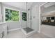 Glass-enclosed shower with tiled walls and flooring, next to double vanity sinks with a large window at 155 Glenside Ln, Duluth, GA 30097
