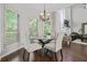 Bright dining room features white shutters, wood flooring, and a glass table surrounded by four upholstered chairs at 155 Glenside Ln, Duluth, GA 30097