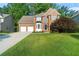 Charming two-story brick home featuring a well-manicured lawn, two-car garage, and mature trees at 155 Glenside Ln, Duluth, GA 30097