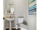 Cozy powder room features a pedestal sink, modern toilet, and stylish art, creating a functional yet inviting space at 155 Glenside Ln, Duluth, GA 30097