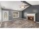 Comfortable living room with gray walls, a fireplace, ceiling fan, vaulted ceiling, and hardwood floors at 173 Michael Ln, Mcdonough, GA 30252