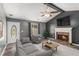 Comfortable living room with gray walls, fireplace, ceiling fan, vaulted ceiling, and neutral furnishings at 173 Michael Ln, Mcdonough, GA 30252