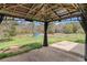 View of covered patio overlooking expansive backyard with lush greenery and detached shed at 173 Michael Ln, Mcdonough, GA 30252