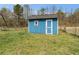 Charming blue storage shed with white trim and secure fencing, great for extra storage and organization at 173 Michael Ln, Mcdonough, GA 30252