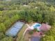 Aerial view of tennis court, outdoor pool, and cozy pool house surrounded by trees at 21 Edgewater Se Dr, Cartersville, GA 30121