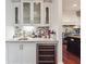 Stylish bar area with a wine fridge, granite countertops, mosaic backsplash, and white cabinetry at 21 Edgewater Se Dr, Cartersville, GA 30121