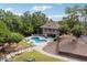 A beautiful pool area is surrounded by mature trees, lounge chairs, and an outdoor fireplace at 21 Edgewater Se Dr, Cartersville, GA 30121