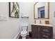 Cozy powder room with wood floors, a pedestal sink, stylish mirror, and modern fixtures at 21 Edgewater Se Dr, Cartersville, GA 30121