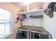 Modern laundry room with front loading washer and dryer and storage shelves at 6221 Woodlore Nw Dr, Acworth, GA 30101