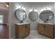 This bathroom features double sinks with round mirrors and contemporary fixtures at 123 Wildwood Dr, Temple, GA 30179