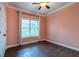 Cozy bedroom featuring warm-toned walls, a large window with natural light, and stylish dark wood flooring at 123 Wildwood Dr, Temple, GA 30179