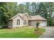 Well-maintained home featuring stone accents, a two-car garage, and a neatly landscaped lawn, showing curb appeal at 123 Wildwood Dr, Temple, GA 30179